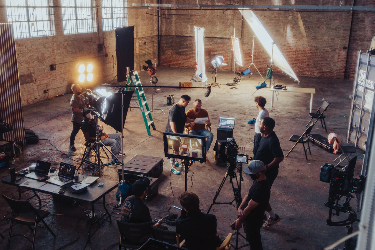 A film crew working around cameras and monitors in a warehouse studio
