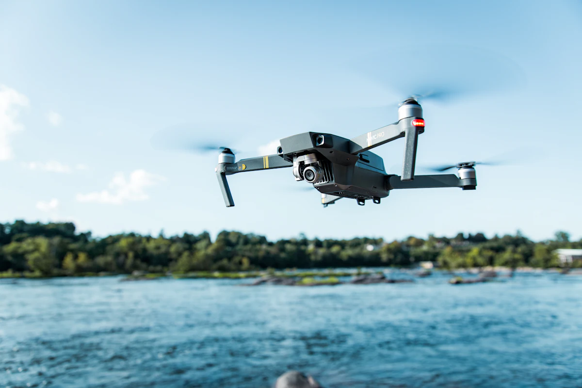 A quadcopter drone hovering over water