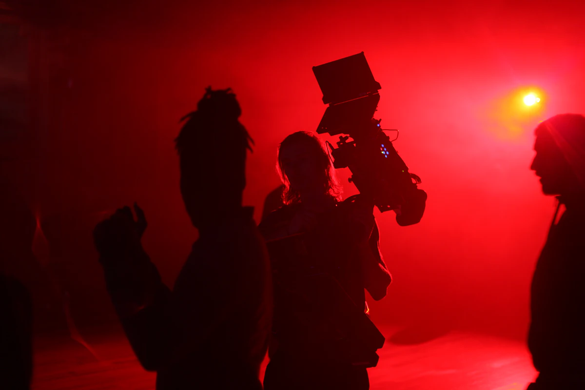 Crew members standing in front of a red light on set