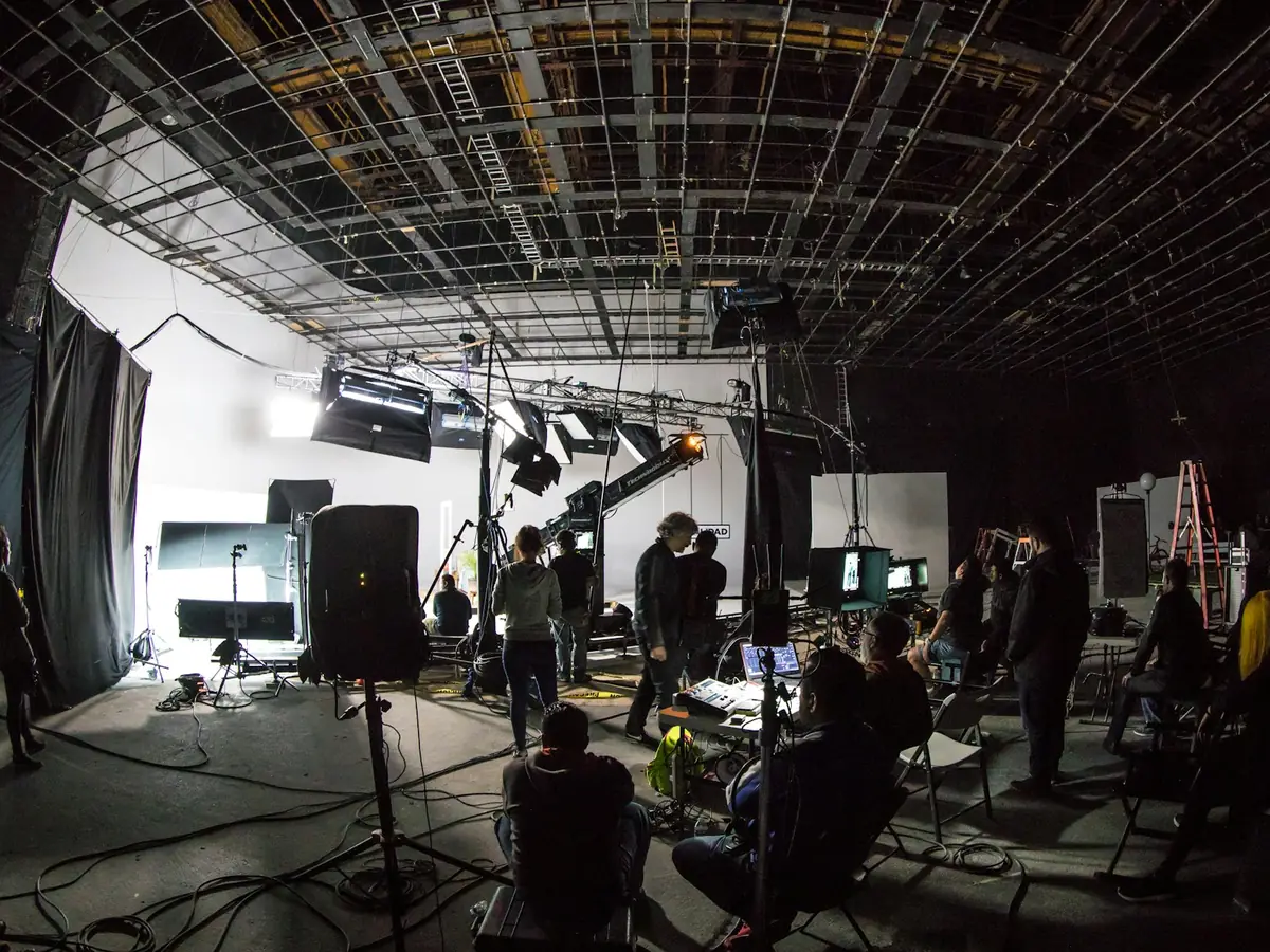 A crew working on a large soundstage under studio lights